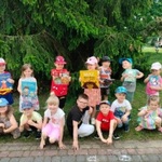 Dzieci z grupy 3 czytają na polanie.