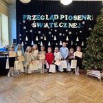 Dzieci pozują do zdjęcia z nagrodami i dyplomami.