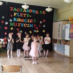 Dziewczynka recytuje wiersz o muzyce .