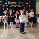 Chłopiec recytuje wiersz o muzyce .