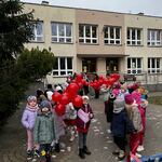 Przedszkolaki prezentują czerwone balony.