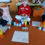 Chłopiec układa wieżę z kubeczków