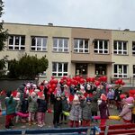 Przedszkolaki pozują do zdjęcia na tle budynku.