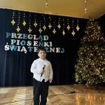 Chłopiec z grupy 4 pozuje z mikrofonem.