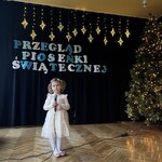 Dziewczynka stoi z mikrofonem.