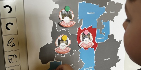 Chłopiec stoi przy tablicy z magnesem..jpg