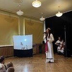 Artystka śpiewa a dzieci wykonują teatr cieni.