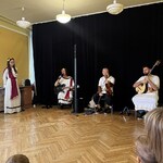Artyści siedzą z instrumentami.