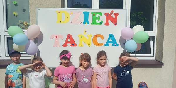 Dzieci pozują przy napisie dzień tańca.jpg