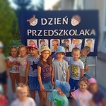 Przedszkolaki pozują na tle napisu Dzień