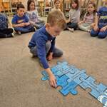 Dzieci z grupy 10 układają niebieskie puzzle