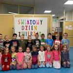 Dzieci pozuję przy napisie Światowy dzień Zwierząt