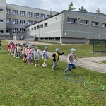 Dzieci skaczą przez obręcze
